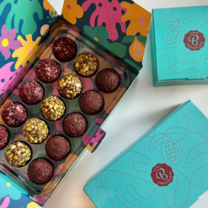Colorful box of assorted brigadeiro chocolate truffles with a teal lid on a white background
